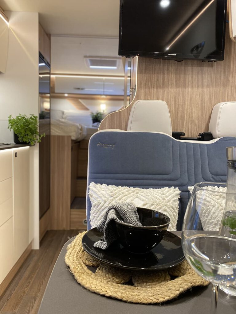 Tisch mit Geschirr und Sitzbank mit grauen Polster