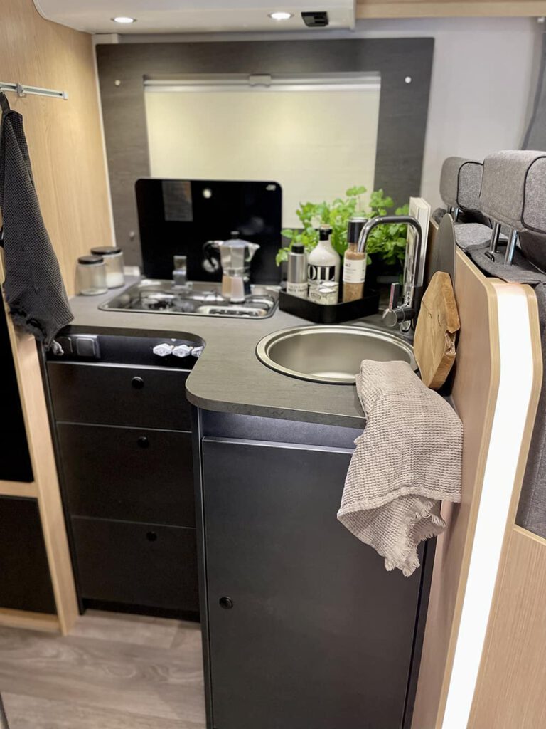 Graue Küchenzeile mit Waschbecken und Gasherd