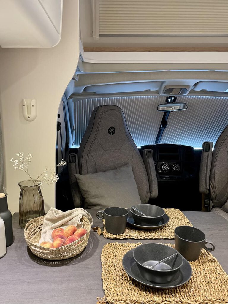 Sitzecke mit grauen Polstersitzen und Geschirr auf dem Tisch