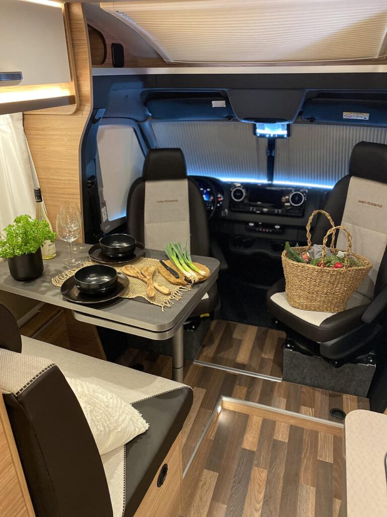 Sitzecke im Wohnmobil mit Dekoration und Einkaufskorb