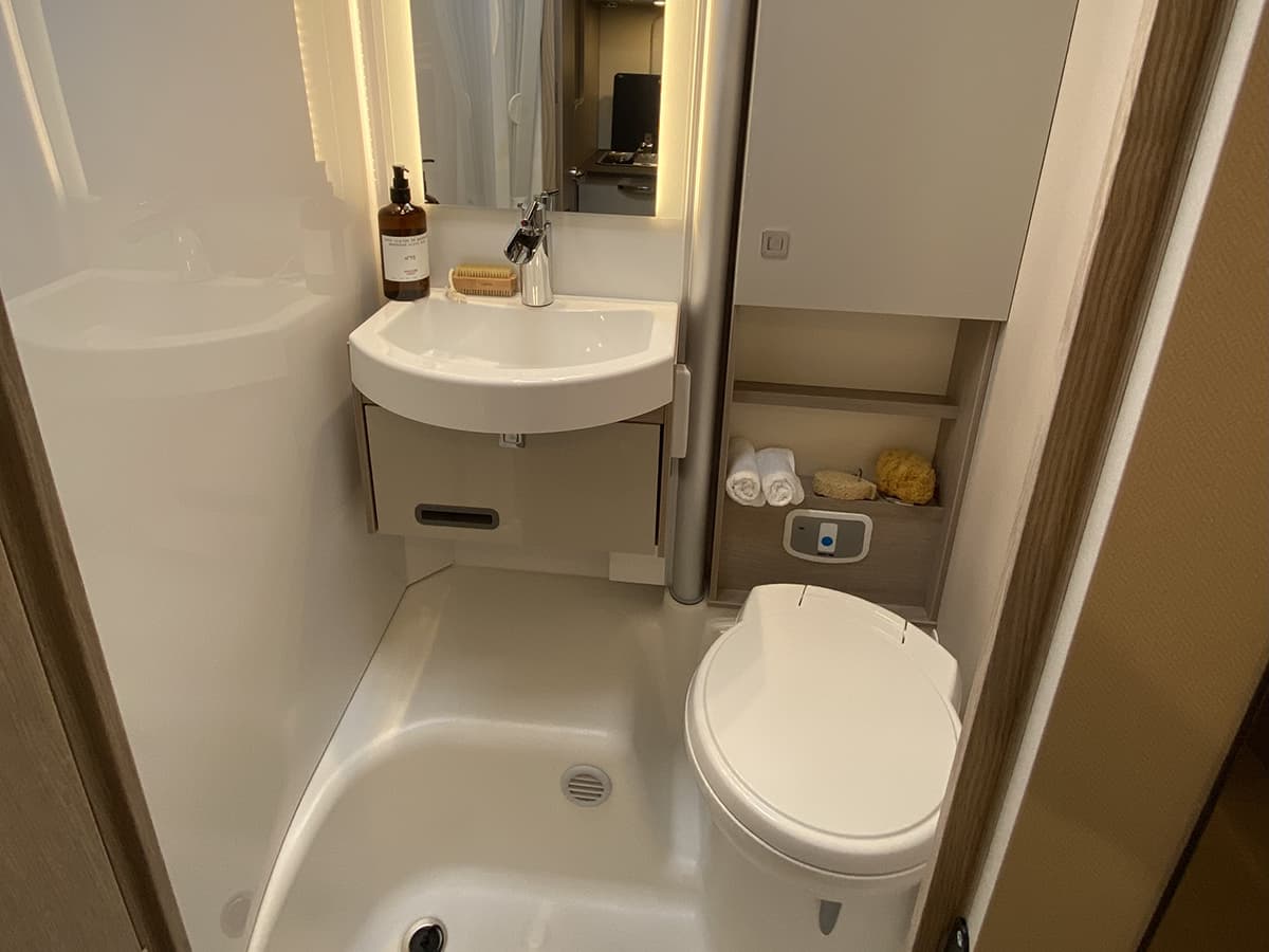 Bad ,it großem Spiegel, Waschbecken und Toilette.