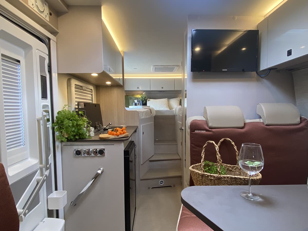 Innenraum mit Küche und Sitzecke mit TV